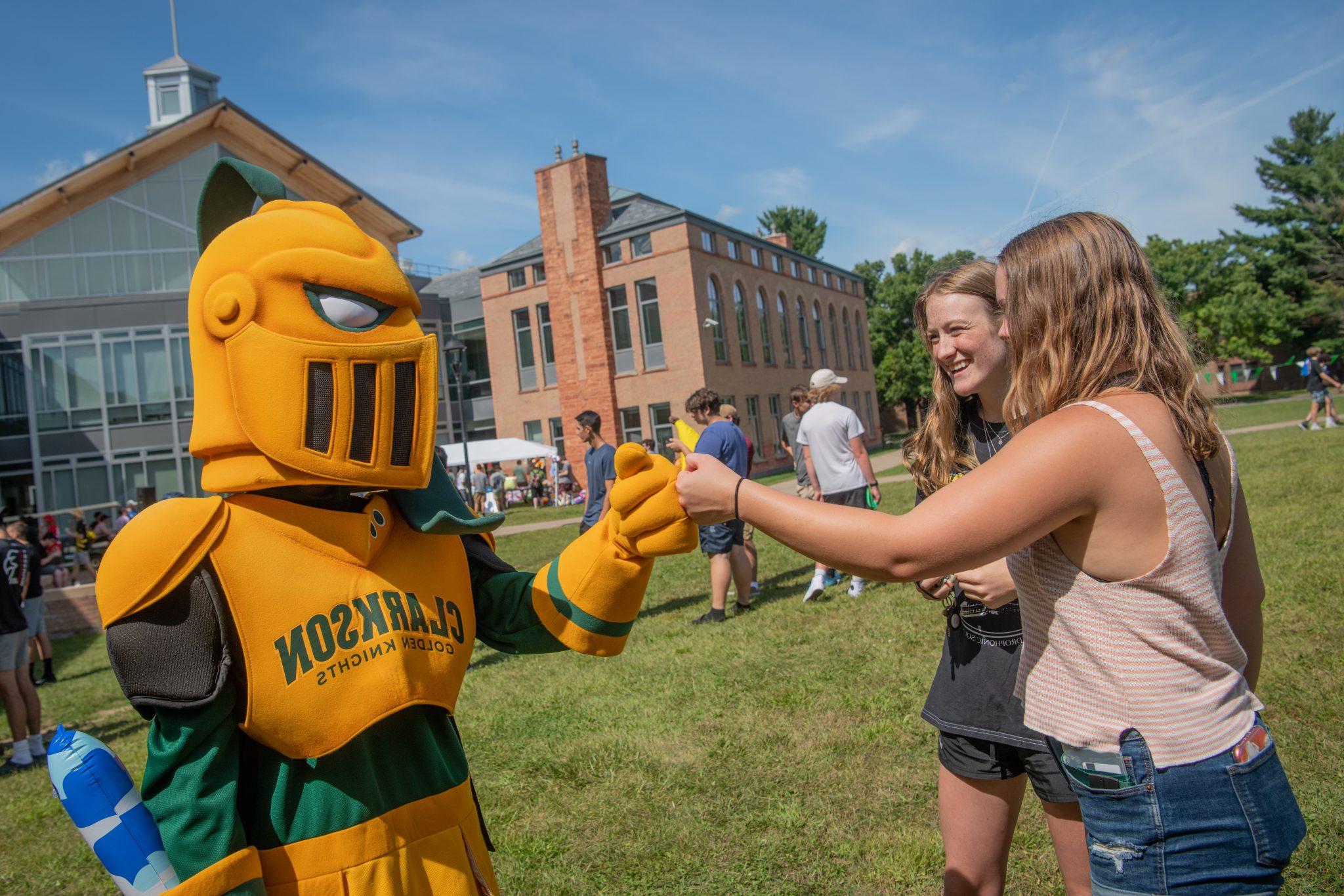 Clarkson student fist bumping Golden Knight. 